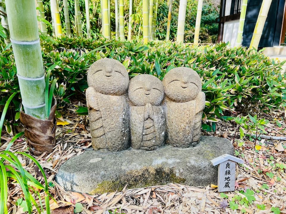 Posing with the cheerful little monk statues at Hase-dera temple in Kamakura