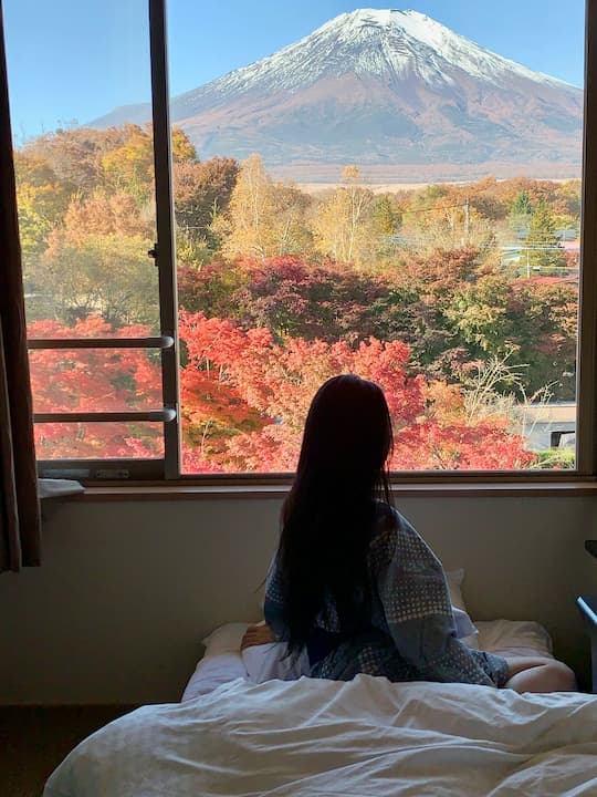 The Fuji View Room at Fuji Matsuzono Hotel offers an unobstructed view of Mount Fuji directly from the bed