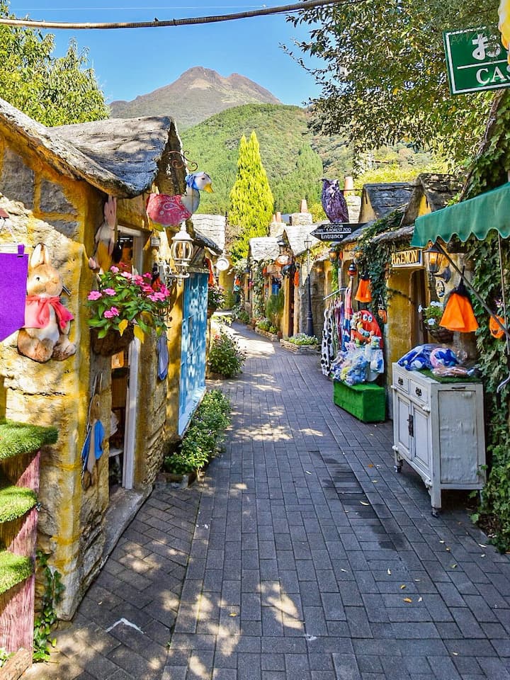 Charming street in Yufuincho Kawakami with quaint boutiques and cafes against a backdrop of mountains