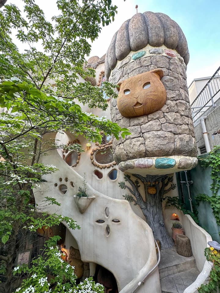 Whimsical cat-themed decorations in Tokyo Kichijōji Petit Mura, including cat-shaped fountains and walls adorned with cat motifs