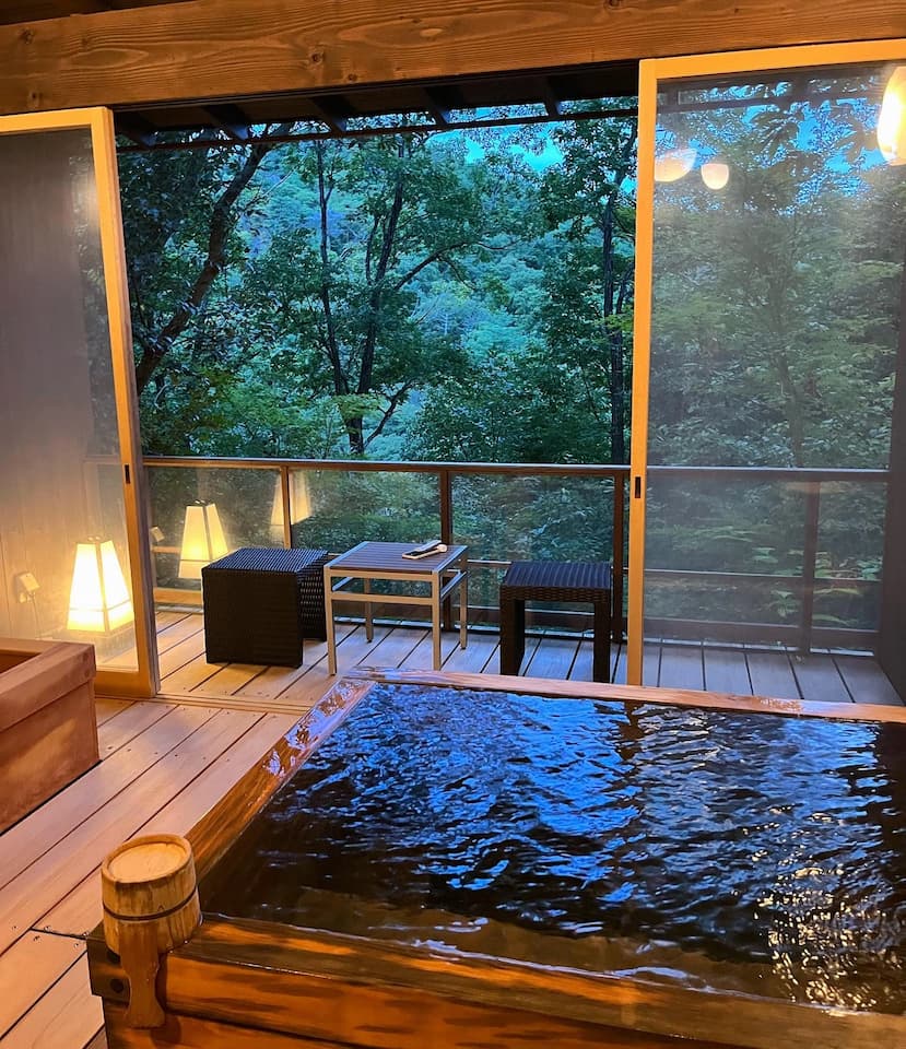 Private onsen bath at Ginsuisou Choraku with tranquil forest views, offering a peaceful and relaxing experience