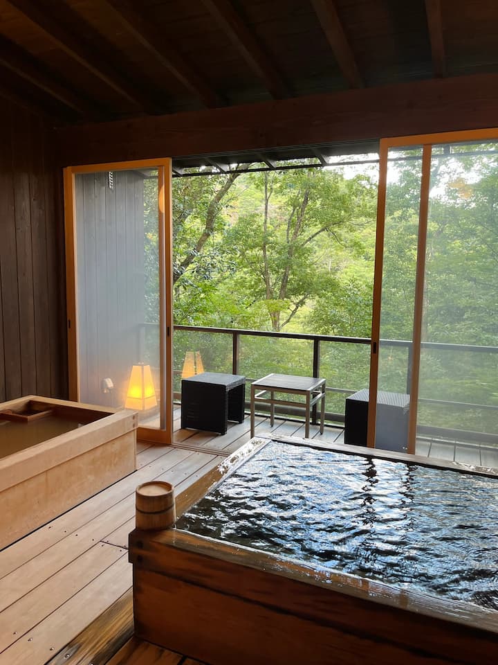 Private onsen bath at Ginsuisou Choraku with tranquil forest views, offering a peaceful and relaxing experience