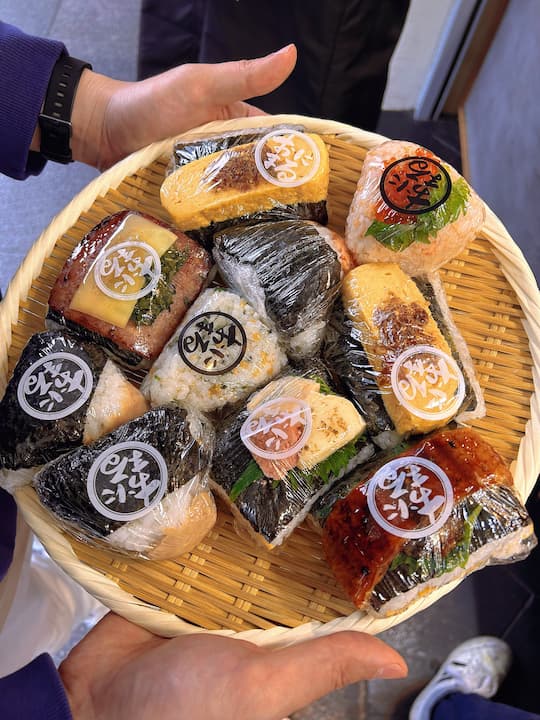 Freshly made onigiri displayed in bamboo baskets at KYOTO ONIMARU onigiri shop