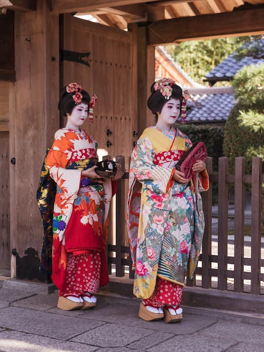 Visitors dressed in kimonos posing for photos at the historic Kiyomizu-dera Temple in Kyoto