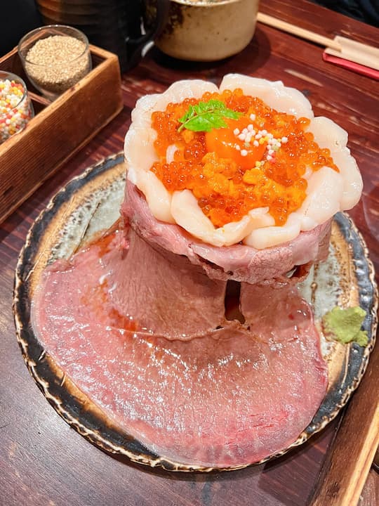 Close-up of Wagyu Volcano dish topped with salmon roe and scallops at Wagyu Volcano OAGARI