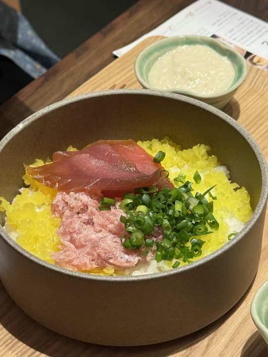 A beautifully presented seafood ochazuke at Kyoto Obuya, located at Kyoto Station, featuring fresh sashimi over rice, ready for the traditional hot broth.