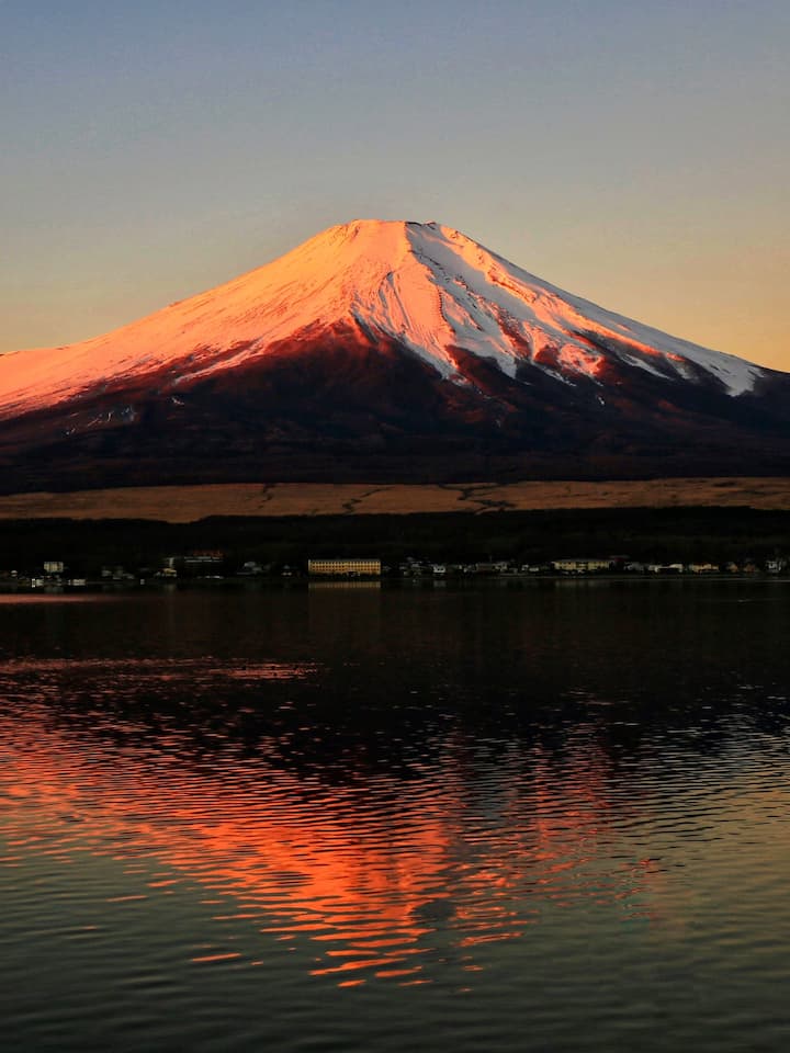 Sunrise over Lake Yamanaka with the majestic Mount Fuji in the background, beautifully reflecting on the calm waters of the lake