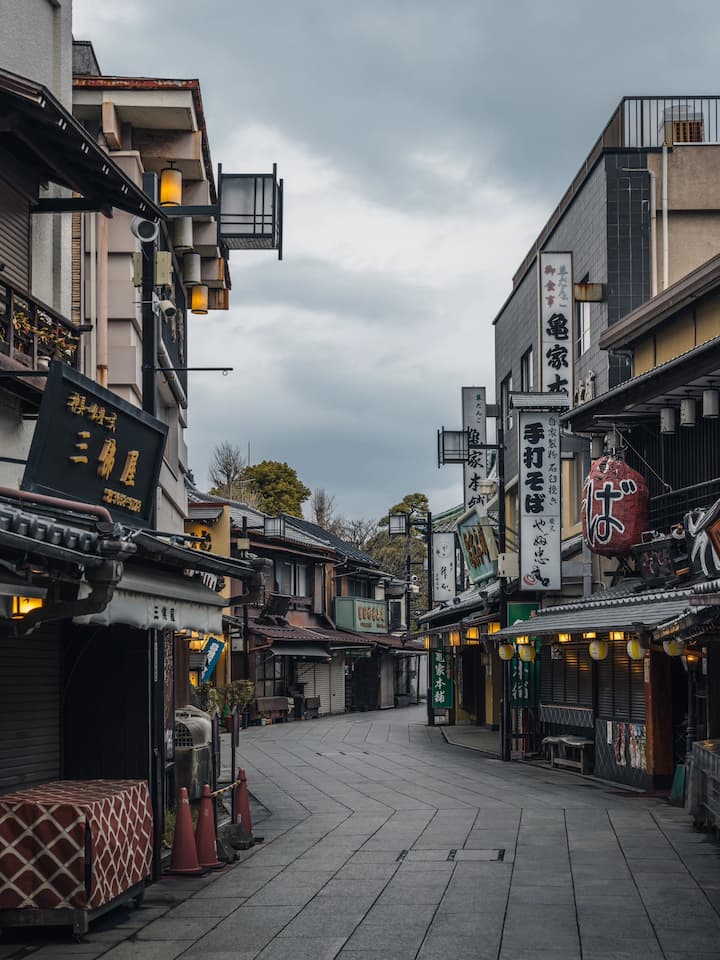 Retro-style shops and buildings along a bustling street in Shibamata, showcasing unique merchandise and traditional Japanese snacks