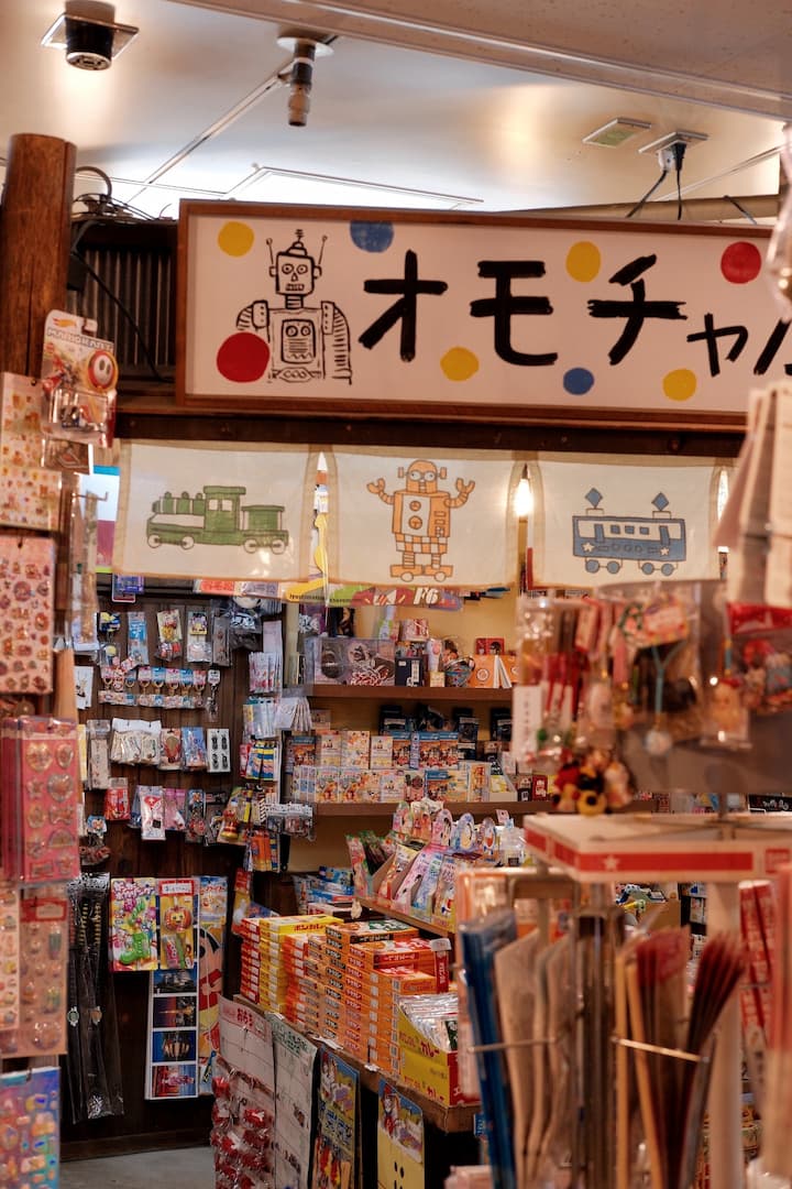 Retro-style shops and buildings along a bustling street in Shibamata, showcasing unique merchandise and traditional Japanese snacks